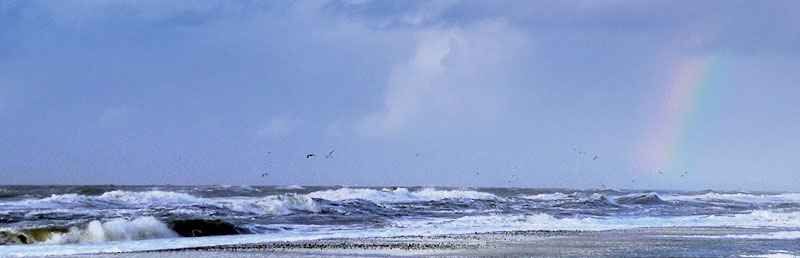 North Sea beach with a rainbow over the waves